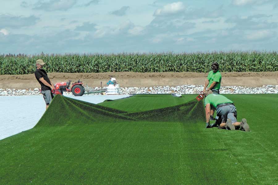 Step 3 in building the artificial turf pitch: Laying the artificial turf on the elastic mat